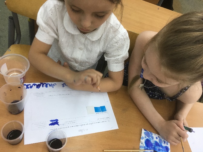 Students are testing the paint, prepared by the recipe, passed to them by another pair of students. On the blank with the recipe there is a print, drawn by the other group. If the shades of ink coincide, both groups know, that they worked correct and careful enough.